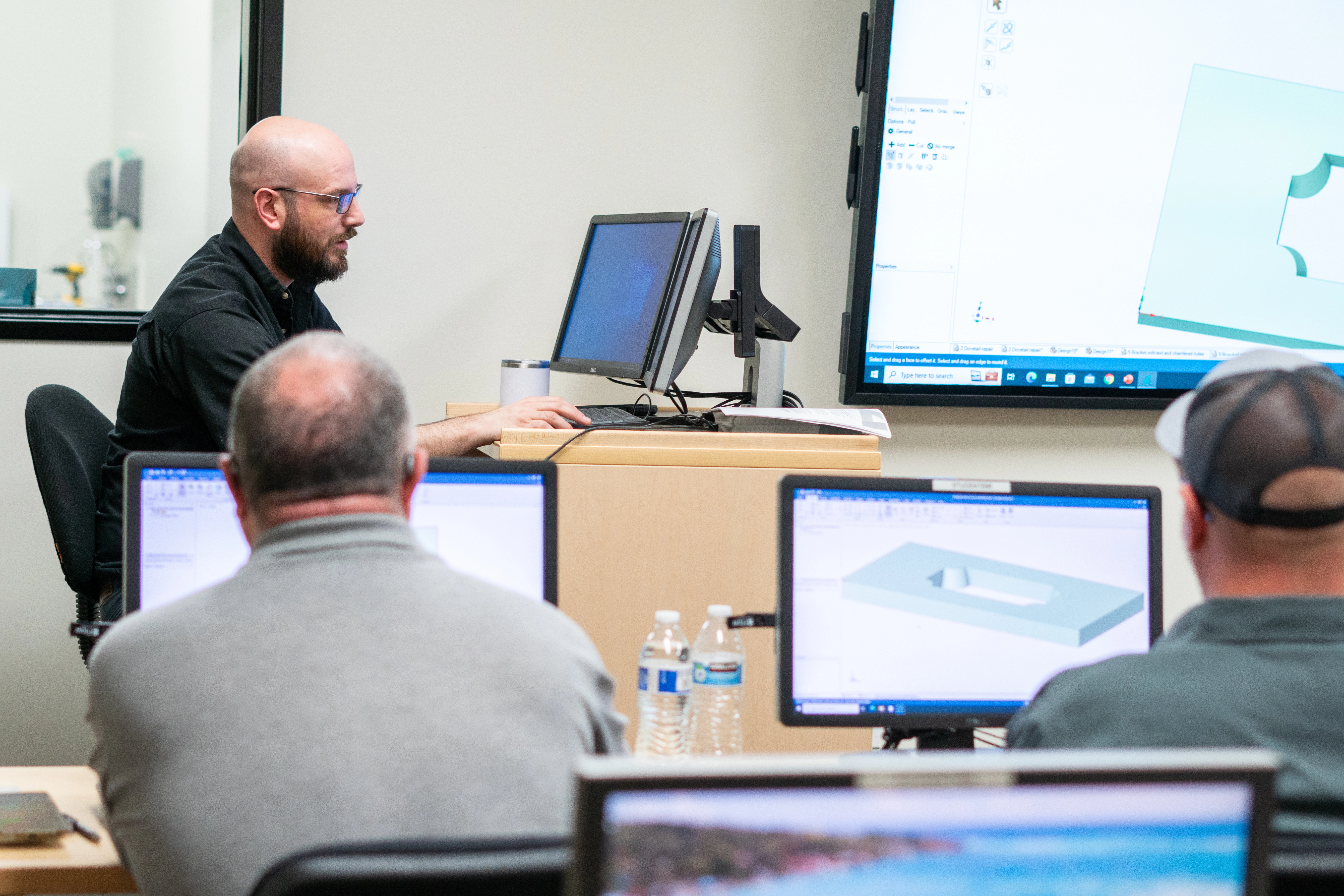 Flow employee instructing a classroom of customers on software, etc