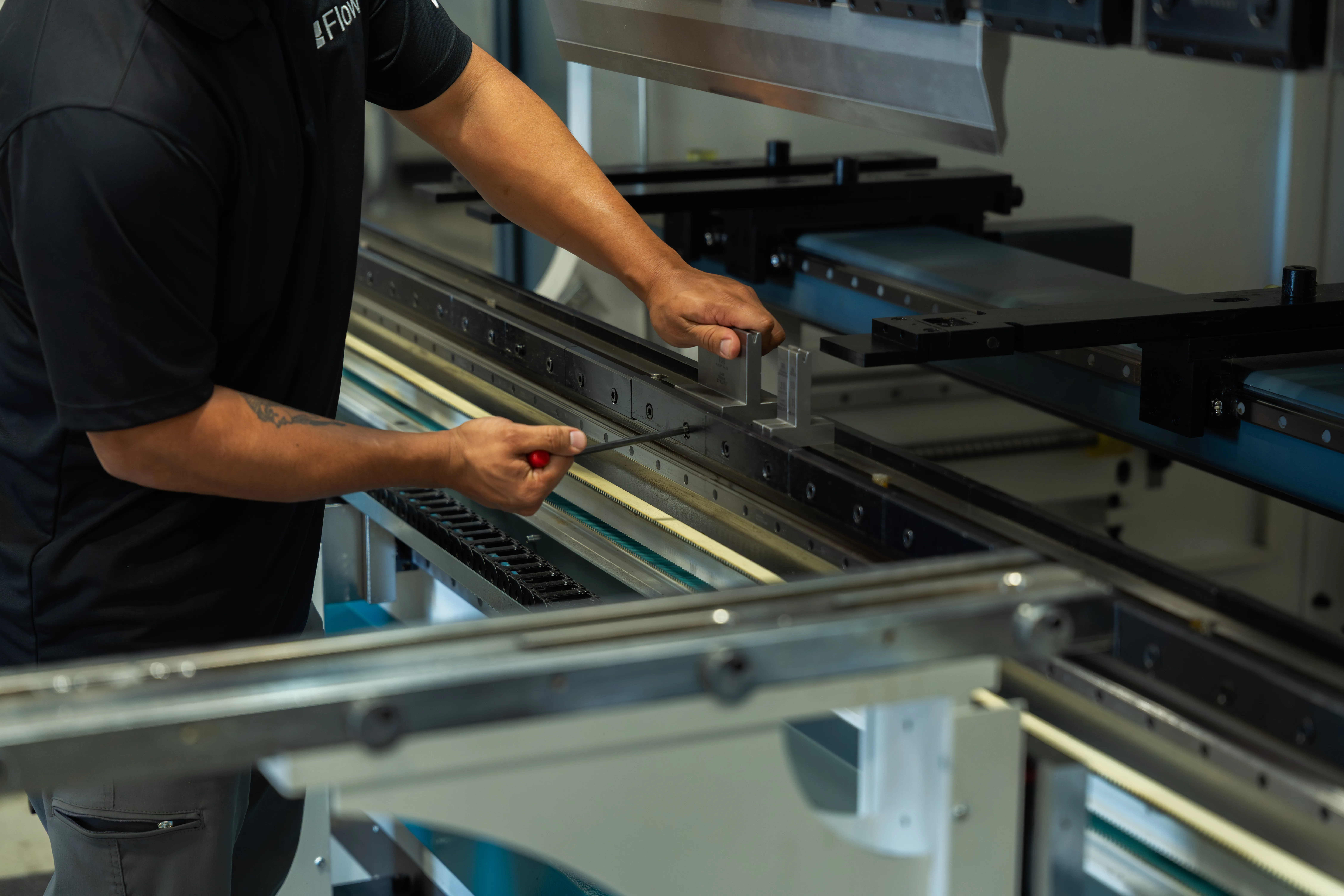 pair of hands performing maintenance on a HyperBend press brake